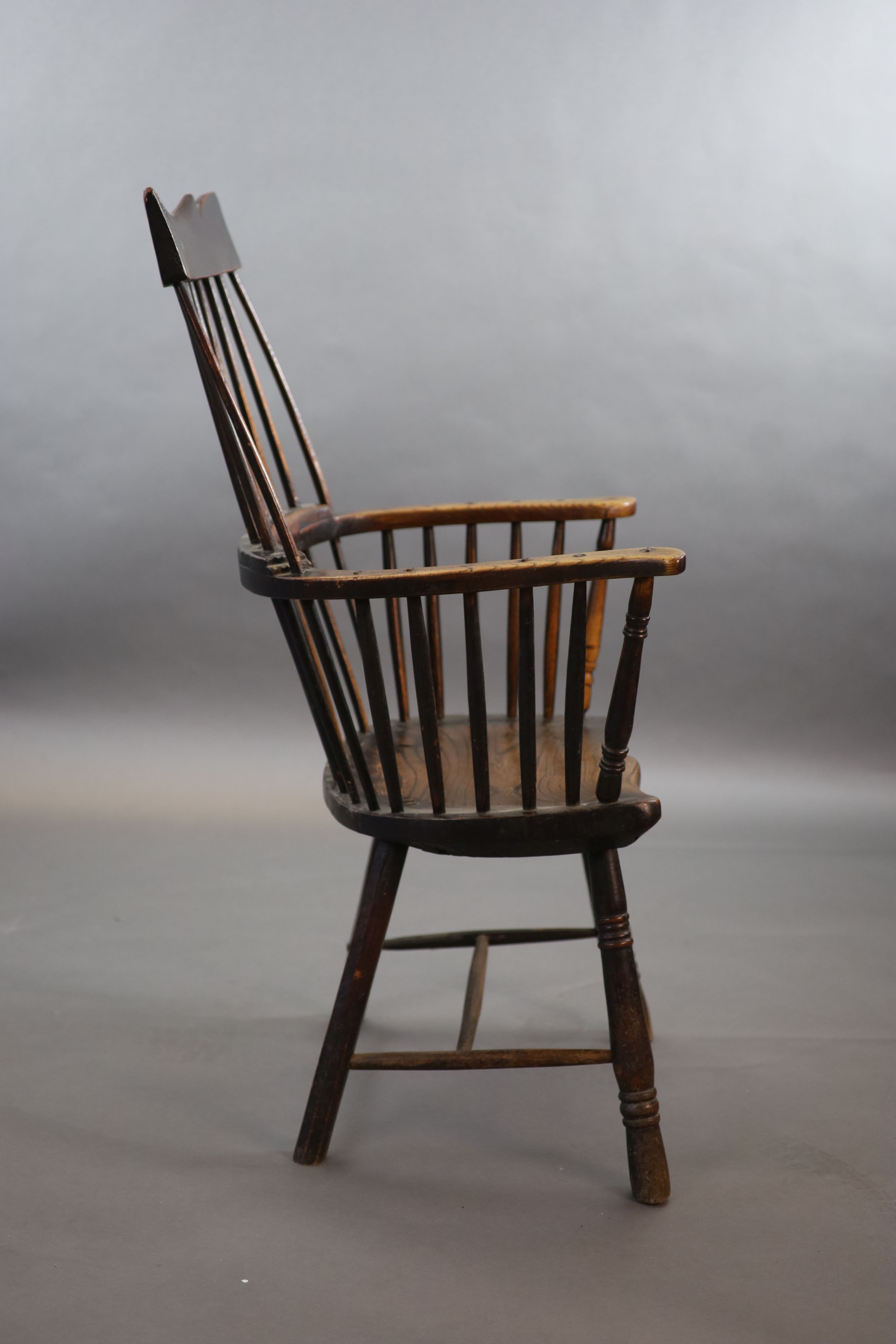 A primitive comb back Windsor armchair, possibly West Country, 67cm wide, 39cm deep, 106cm high.